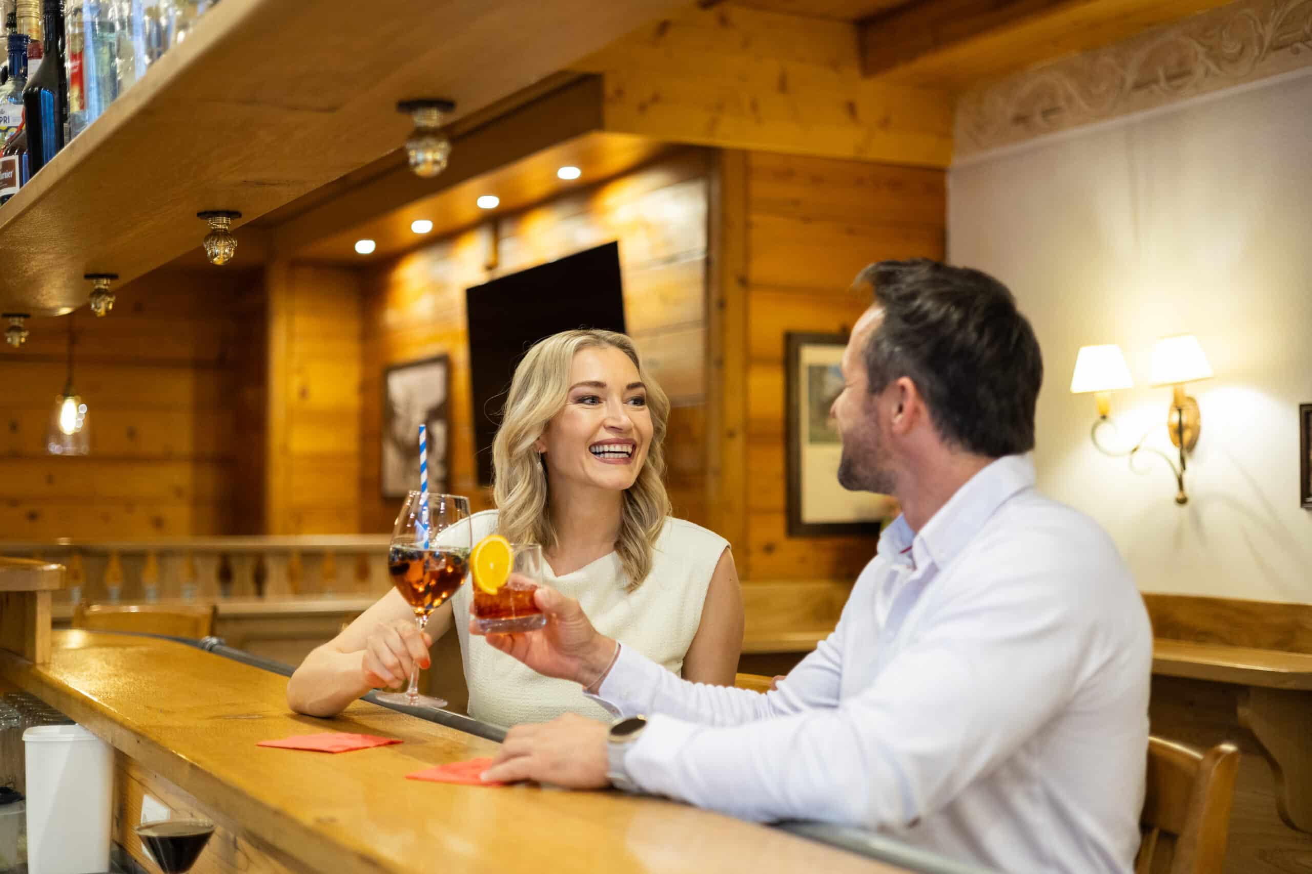 Ein Urlaubsp&auml;rchen trinkt Cocktails an der gem&uuml;tlichen Hotelbar Bischofsm&uuml;tze Filzmoos