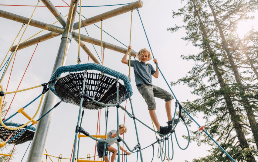 Junge klettert auf Kletterspielplatz am Salzburger Geisterberg